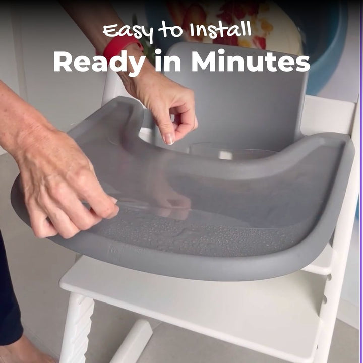 Women hands installing a suction sticker on a Stokke Tripp Trapp tray with water application method..