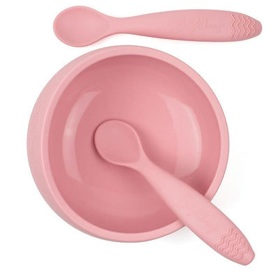 A pink silicone suction bowl and two matching silicone spoons by Brightberry. The bowl has a large capacity and a strong suction base that keeps it in place during mealtime. The spoons are soft and flexible, making them gentle on gums. This set is perfect for babies and toddlers who are learning to self-feed.