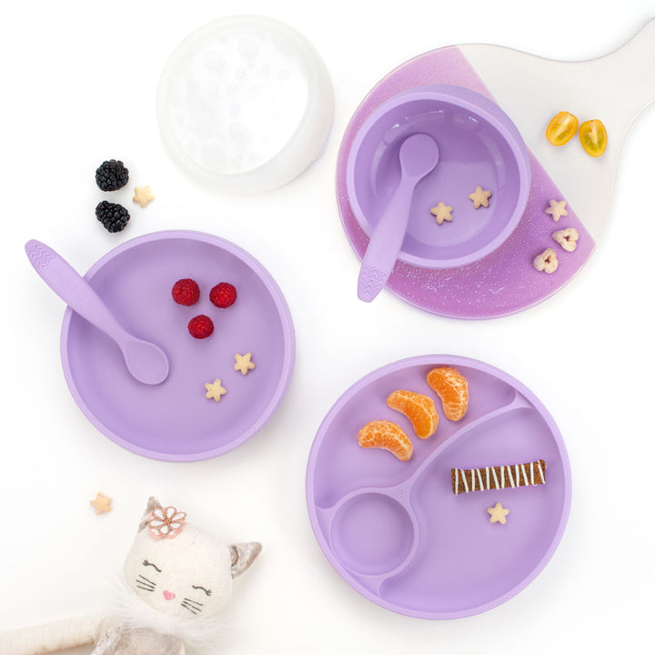 Purple children's dining set with bowl, lid, plates, and spoons on a white background