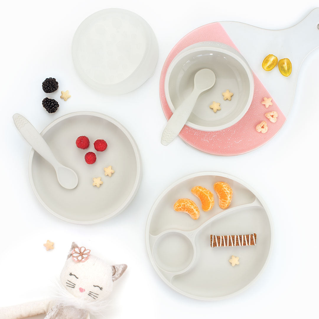 Children's dining set in white with plates, bowls, and utensils on a white background