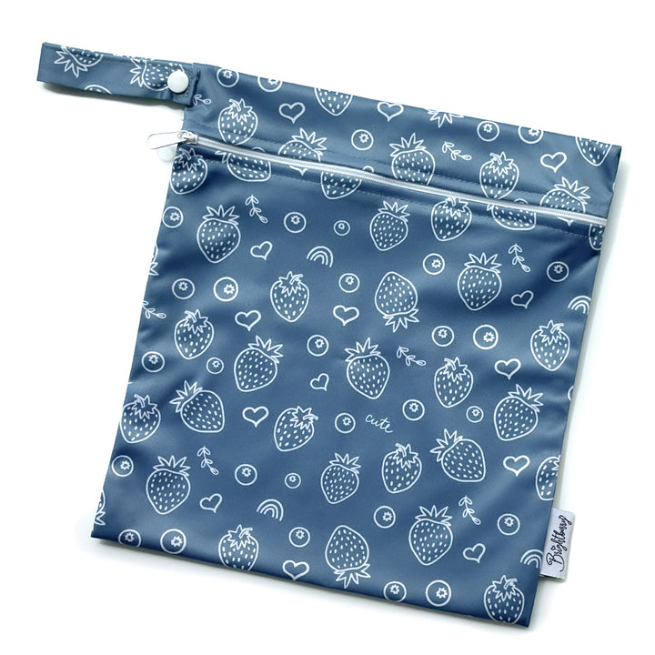 Blueberry navy blue waterproof bag with white strawberry print, zip closure and snap-button carry handle.