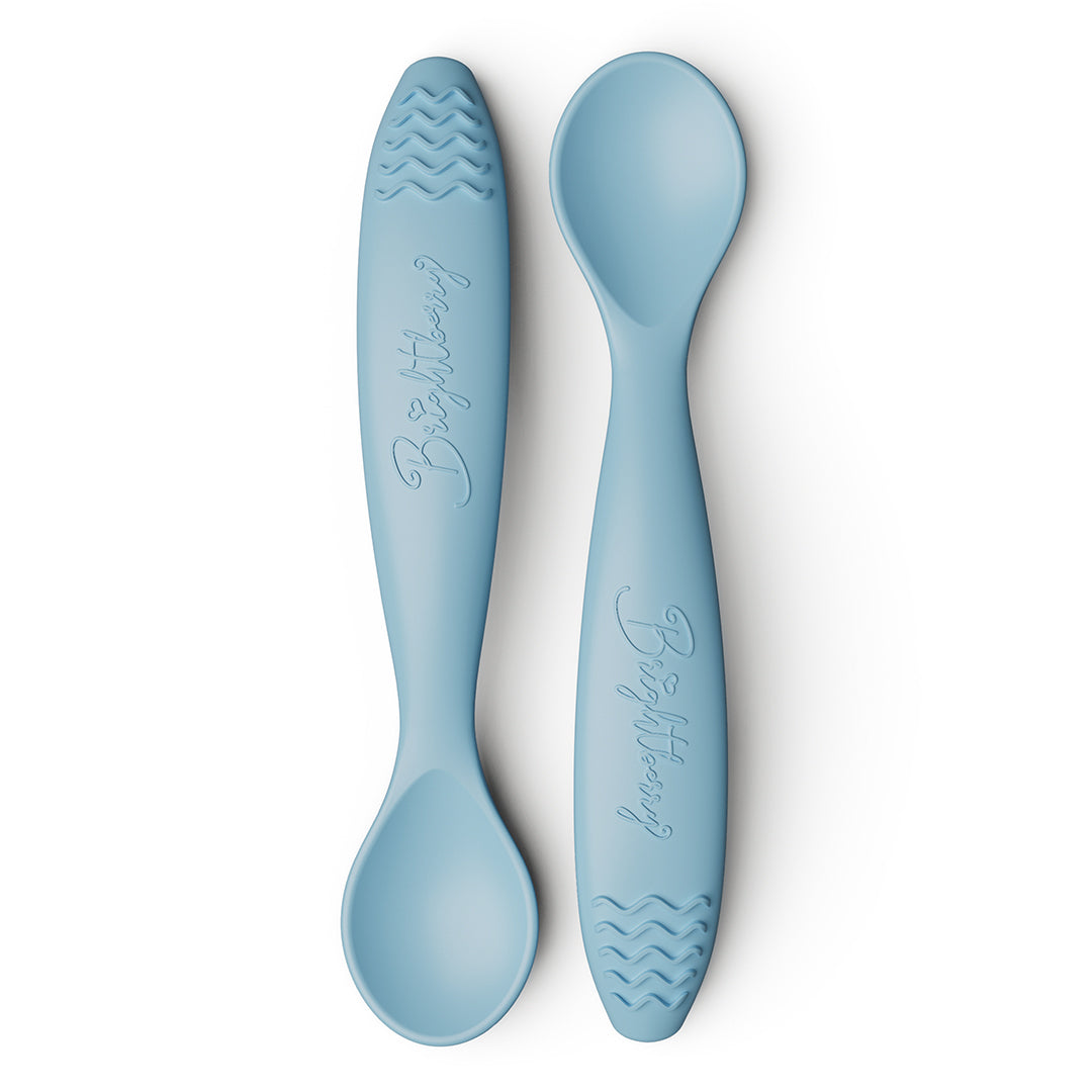 Two light blue baby spoons with textured teething handles on a white background.