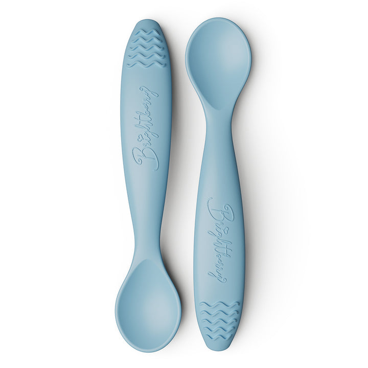 Two light blue baby spoons with textured teething handles on a white background.