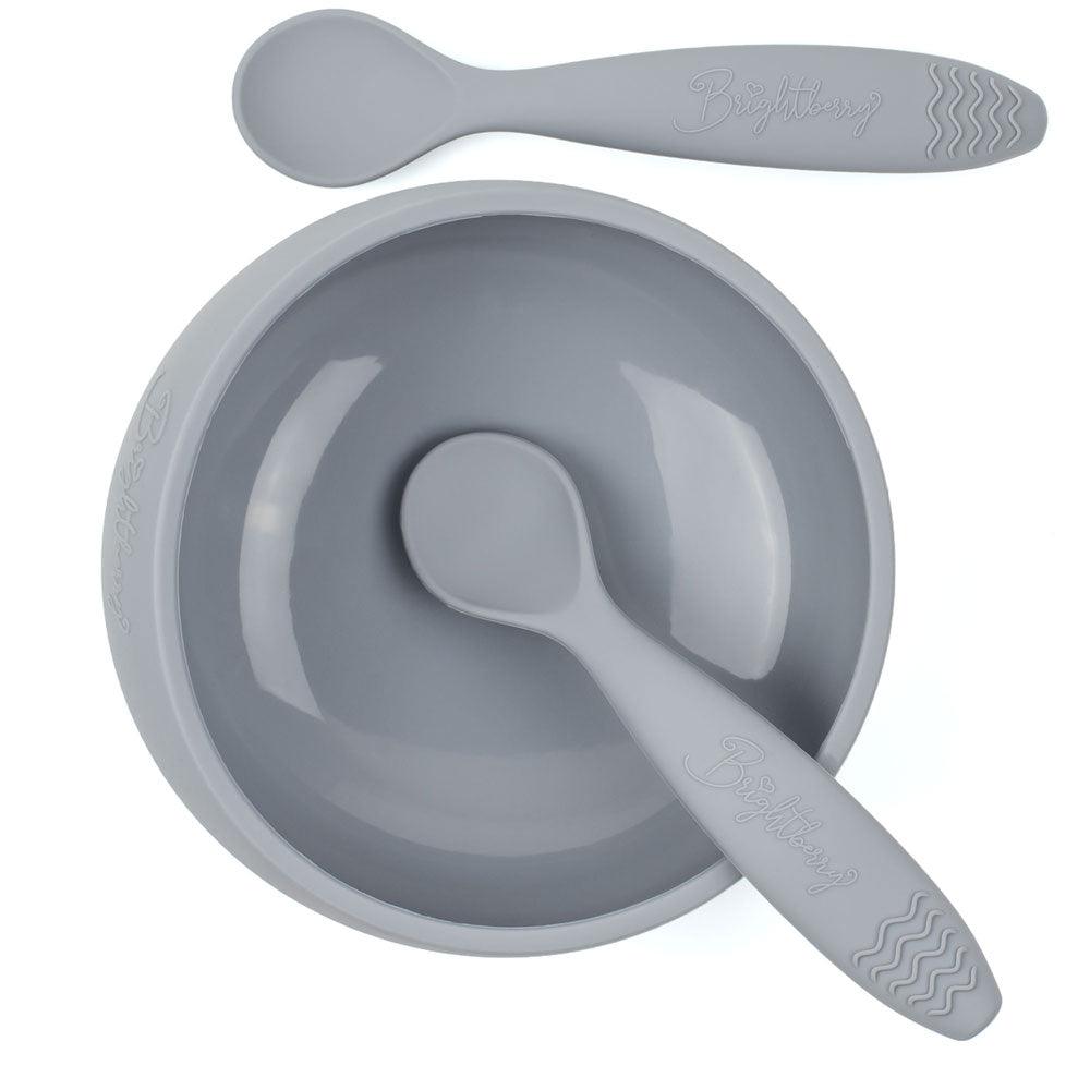 A slate grey silicone suction bowl with two silicone spoons. The bowl has a large capacity and a strong suction base that keeps it in place during mealtime. The bowl is also designed with easy scooping curves to help babies and toddlers feed themselves. The two spoons are soft and flexible, making them gentle on gums. The bowl and spoons are BPA-free and dishwasher safe.