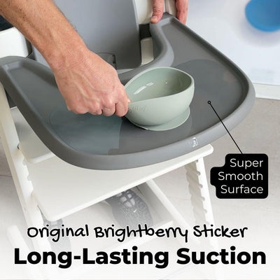 A person pulling a bowl from a high chair tray. The high chair has a smooth surface and a long-lasting suction sticker so the bowl doesn't budge.