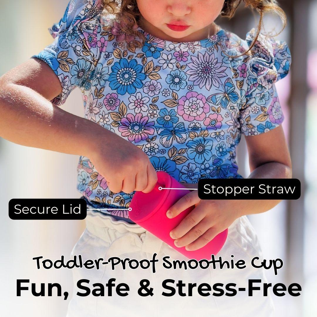 A child securely holding a Brightberry Toddler-Proof Smoothie Cup in pink. The image highlights features such as a 'Secure Lid' and a 'Stopper Straw', emphasizing the product's safety and ease of use. Text overlay states "Toddler-Proof Smoothie Cup Fun, Safe & Stress-Free," suggesting a carefree and enjoyable drinking experience for young children.