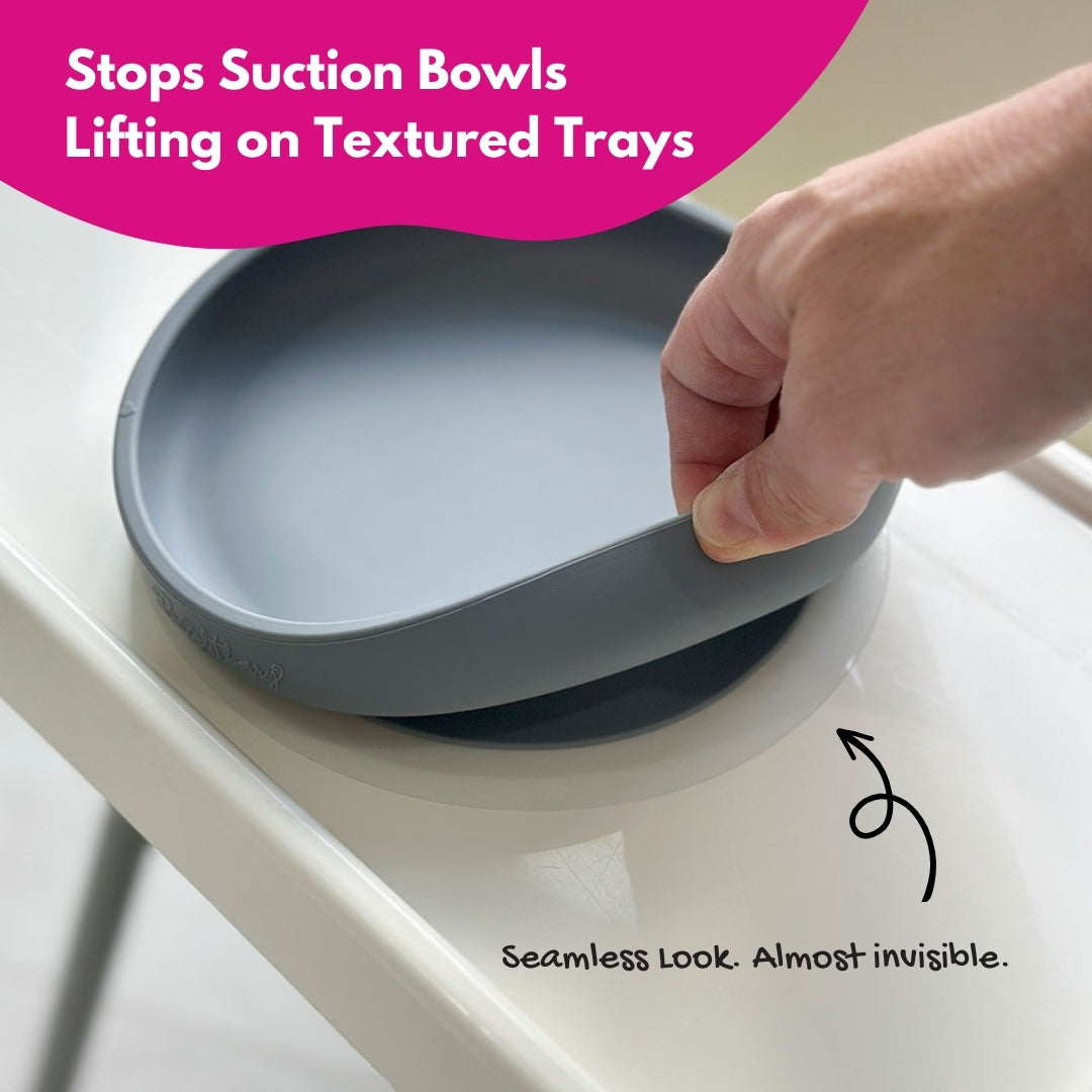 Suction plate being pulled off the Ikea high chair Antilope with text indicating it stops suction bowls from lifting.