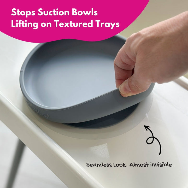 Suction plate being pulled off the Ikea high chair Antilope with text indicating it stops suction bowls from lifting.