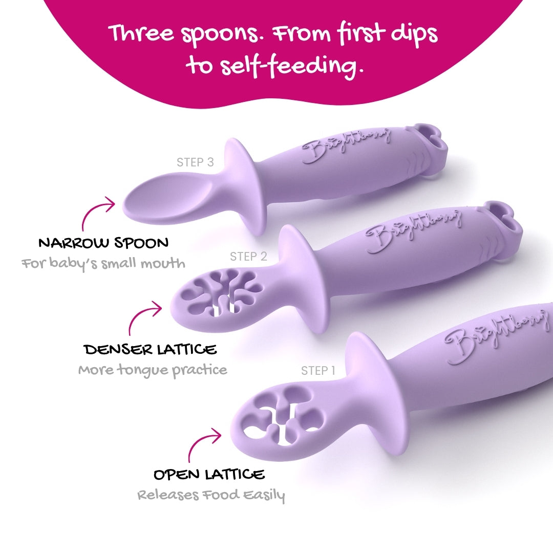 Three lilac baby training spoons arranged diagonally on a white background with explanatory text labels for Step 1, Step 2, and Step 3, plus a pink header reading 'Three spoons. From first dips to self-feeding.