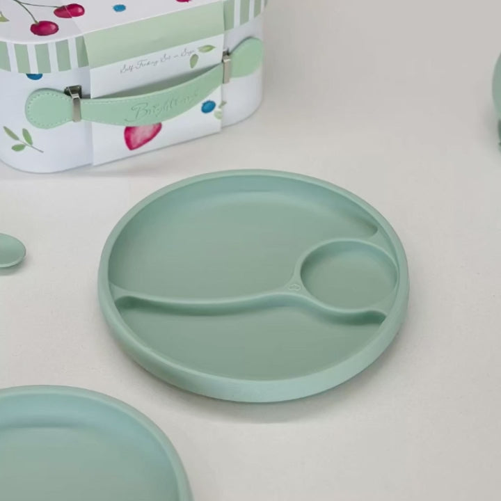 Video showing whats inside Self feeding gift set by Brightberry. It shows silicone suction divided plate, easy scooping plate, bowl, bowl lid and two spoons, all in sage green colour.