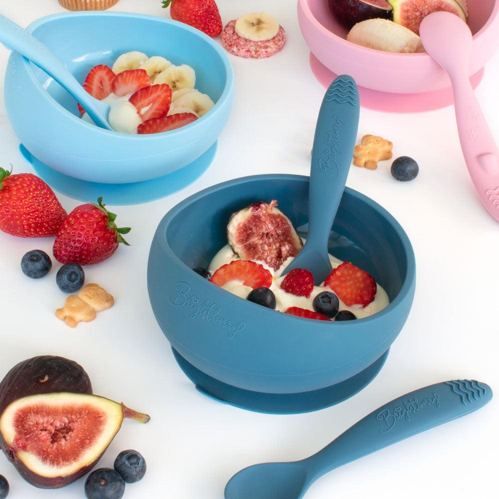 silicone suction bowls with silicone spoons in blue and pink with yogurt and fruit by Brightberry